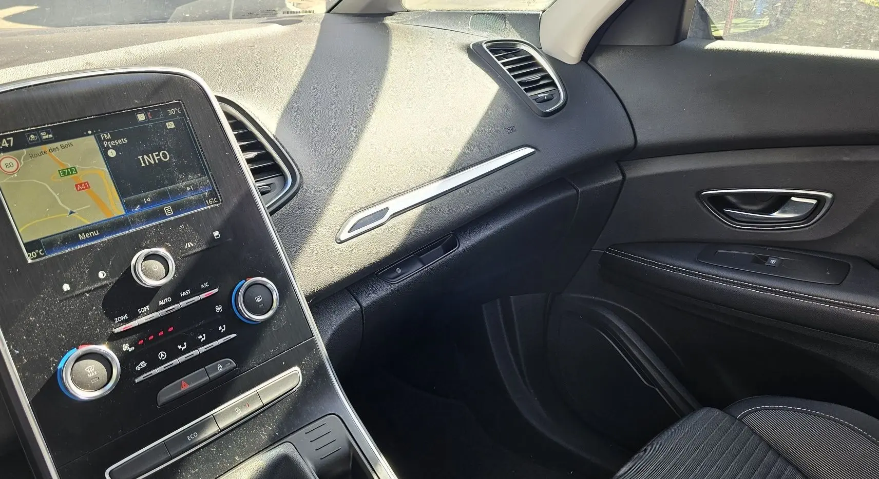 Vue intérieure côté passager du tableau de bord et de la console centrale d'un Renault Scenic 2020 finition Business.