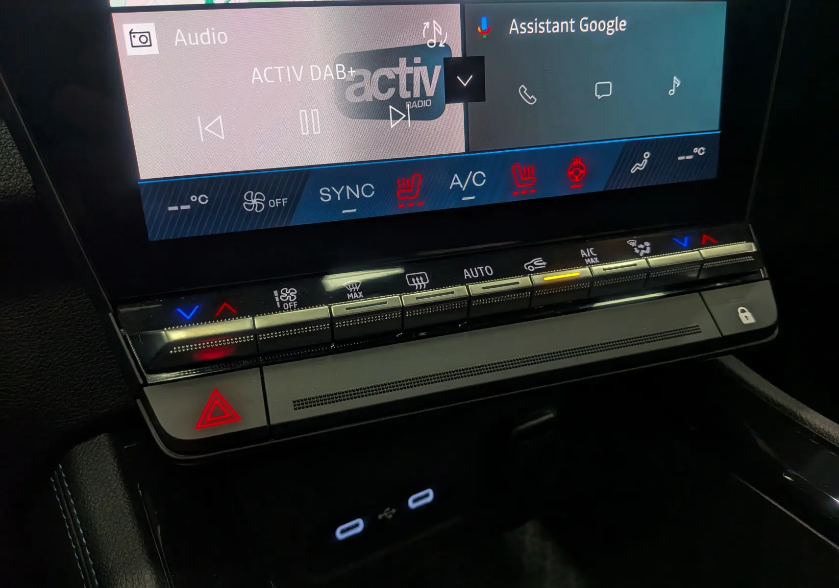 Détail de la console centrale du Renault Austral 2025 hybride, avec commandes climatisation et écran tactile affichant Google Assistant.