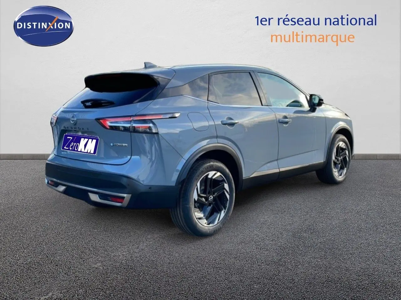 Vue 3/4 arrière droite d'un Nissan Qashqai gris argile métal 2025 avec jantes noires et toit noir.