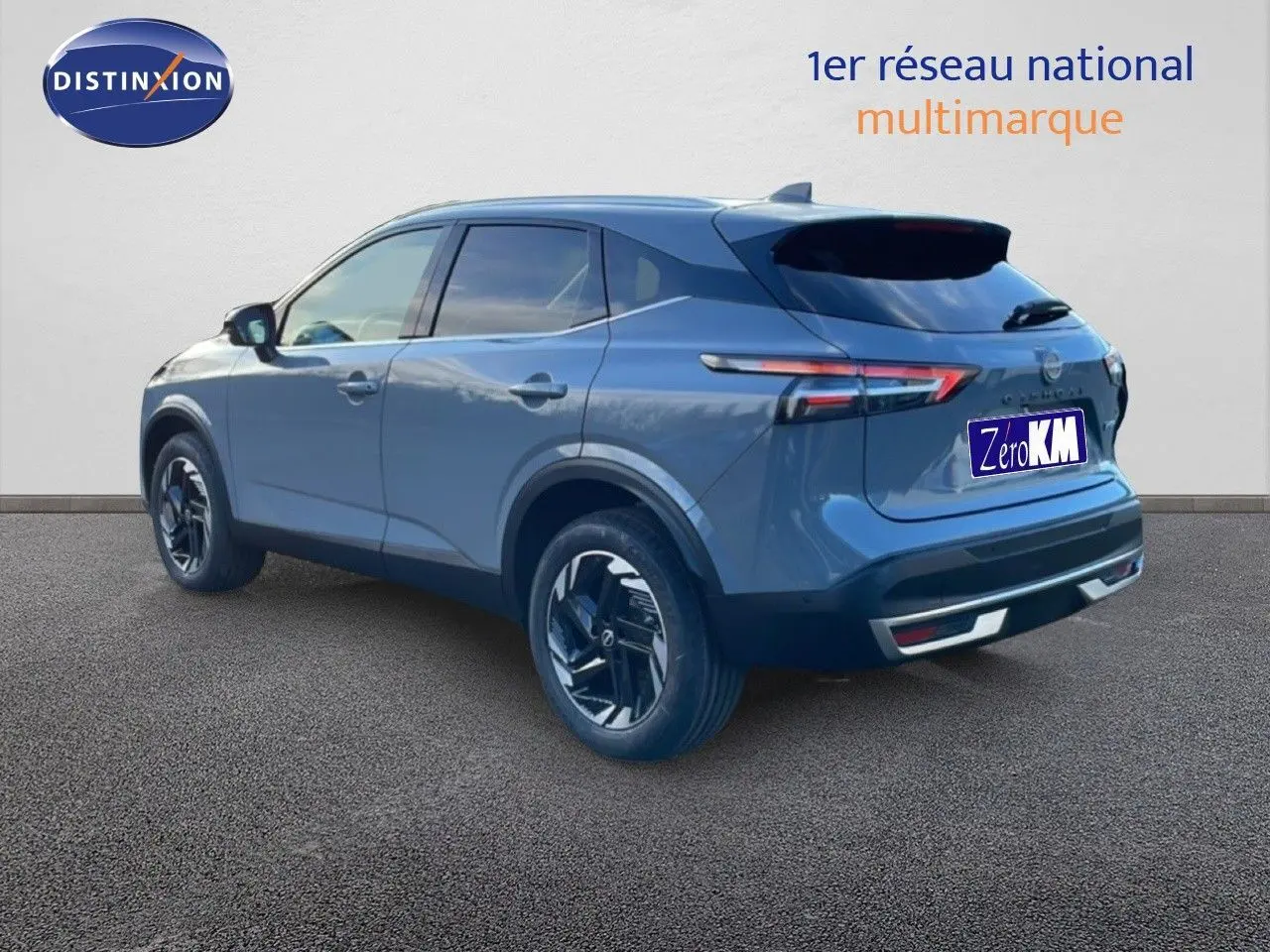 Nissan Qashqai 1.5 E-POWER gris argile métal vu de 3/4 arrière droit avec jantes noires et feux LED distinctifs.