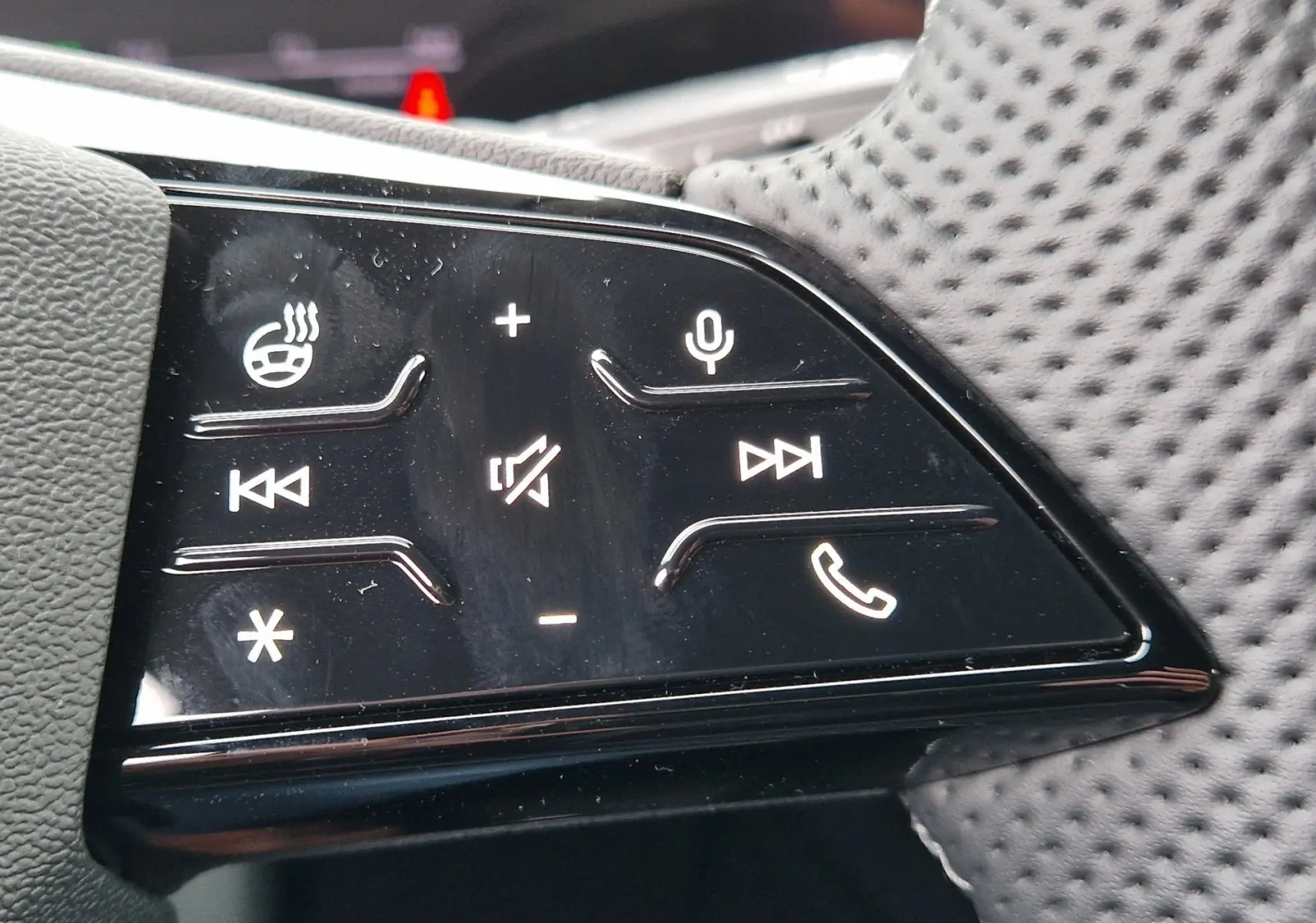 Gros plan sur les commandes tactiles du volant perforé de l'Audi Q6 e-tron Performance S-Line gris Manhattan 2025.