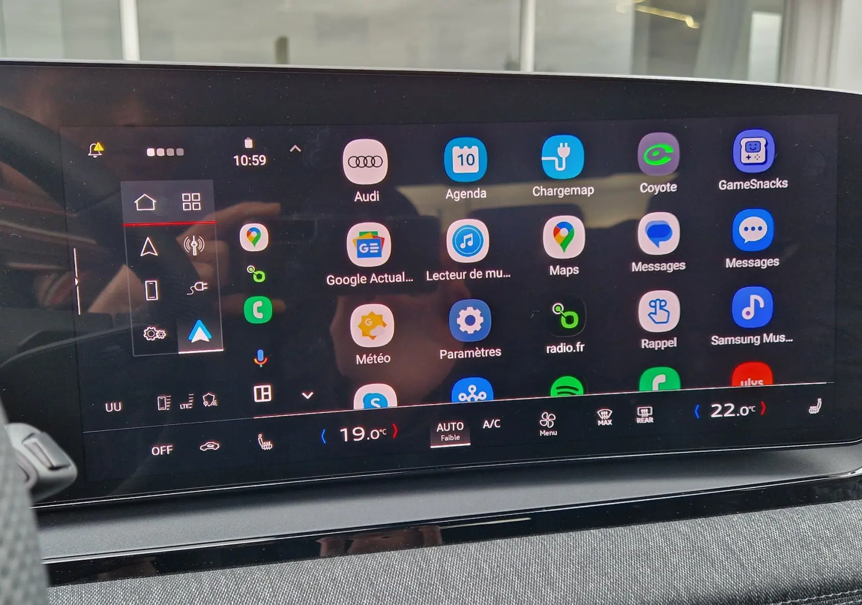 Écran tactile central de l’Audi Q6 e-tron Performance S-Line 2025 affichant les applications et la climatisation, intérieur gris.