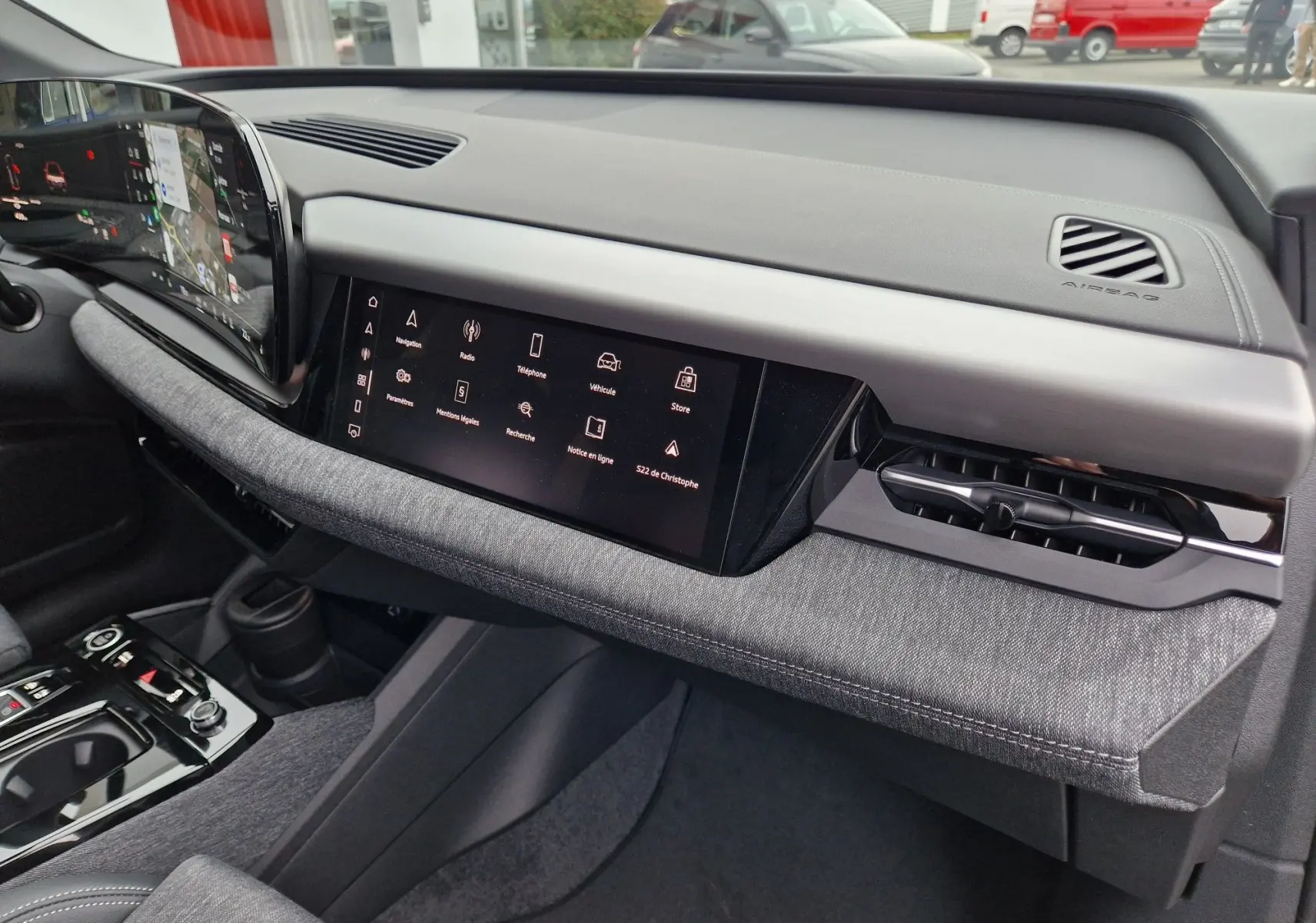 Vue intérieure du tableau de bord de l'Audi Q6 e-tron Performance S-Line 2025, avec écran tactile et finition grise Manhattan.