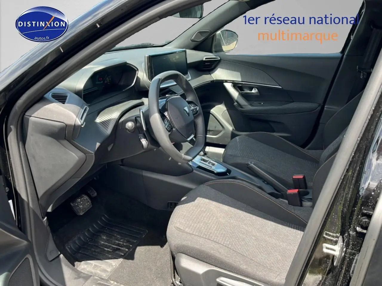 Intérieur avant droit de la Peugeot 2008 noire 2025, montrant le tableau de bord et les sièges tissu gris.