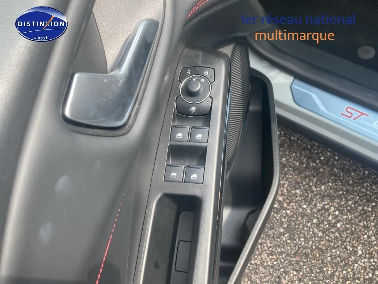 Gros plan sur la porte côté gauche du Ford Puma gris cactus 2025, avec commandes vitres et seuil ST visible.