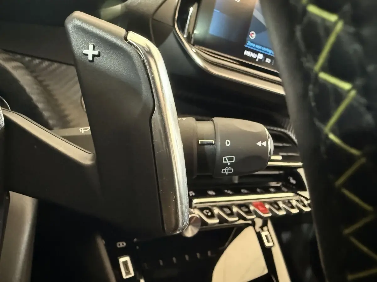 Gros plan sur la palette de changement de vitesse + côté droit du volant d'une Peugeot 2008 GT Pack 2021, intérieur noir.