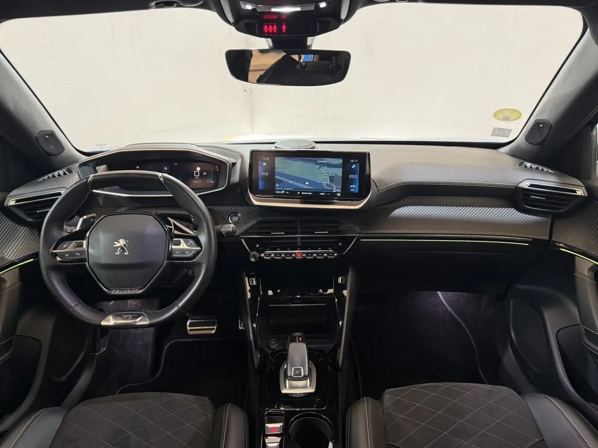 Vue intérieure avant du Peugeot 2008 GT Pack 2021, tableau de bord noir avec écran tactile central et volant compact cuir.