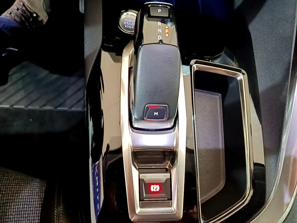 Le levier de vitesse automatique noir et chrome du Peugeot 5008 2020 avec bouton de frein à main électrique allumé.