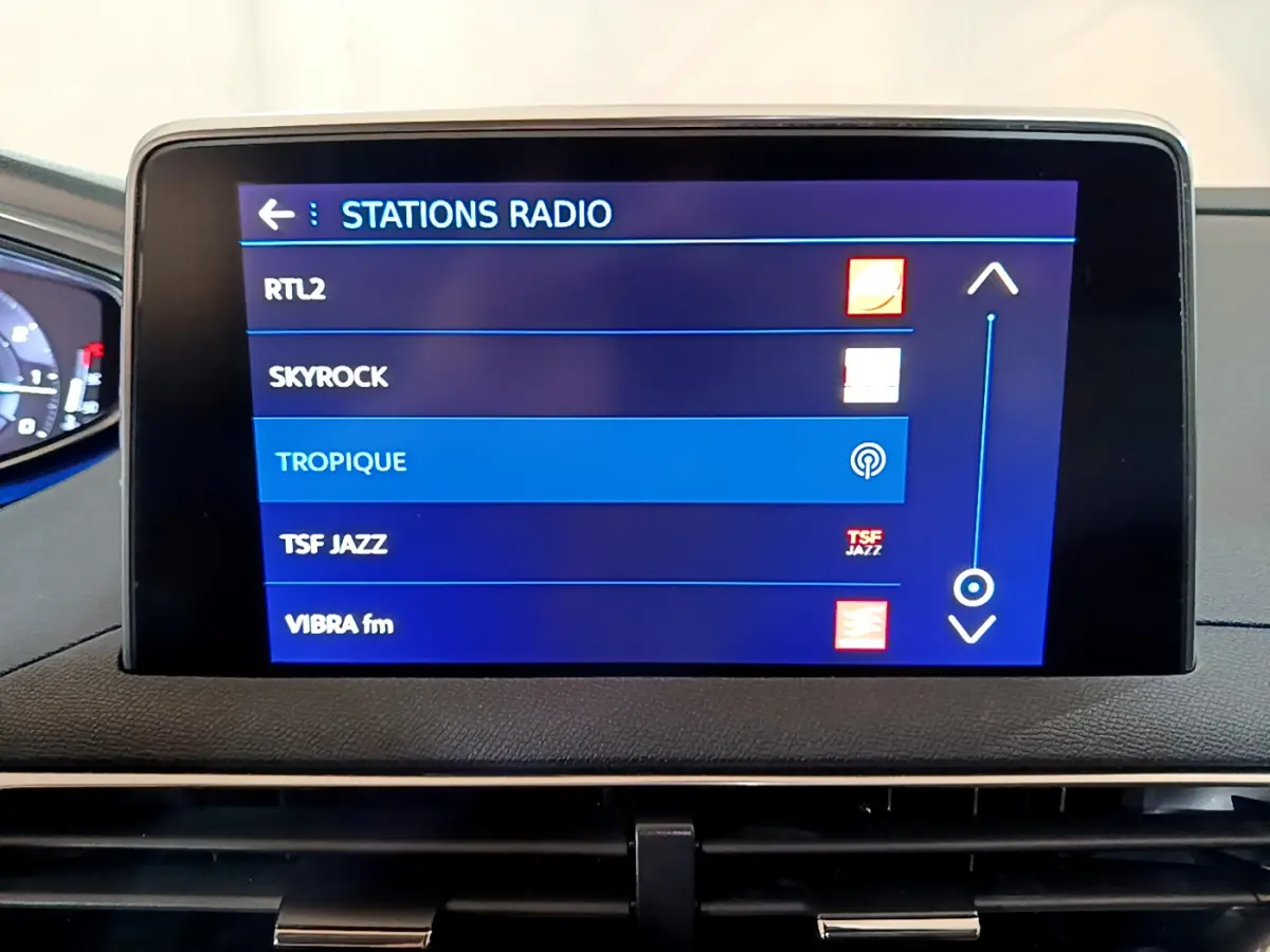 Écran tactile central du tableau de bord du Peugeot 5008 gris clair affichant la liste des stations radio.