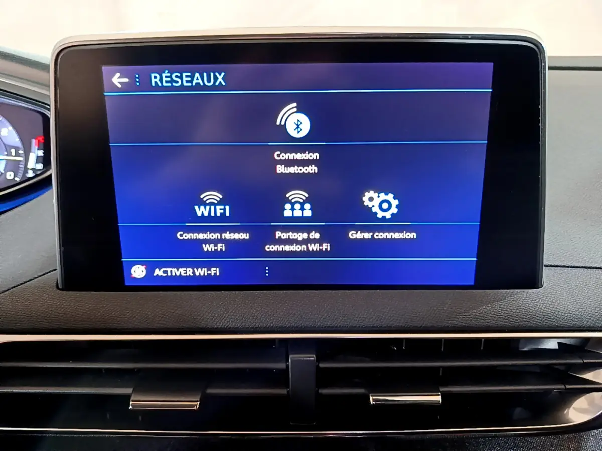 Écran tactile central du tableau de bord du Peugeot 5008 gris clair affichant les options de connexion réseau Bluetooth et Wi-Fi.