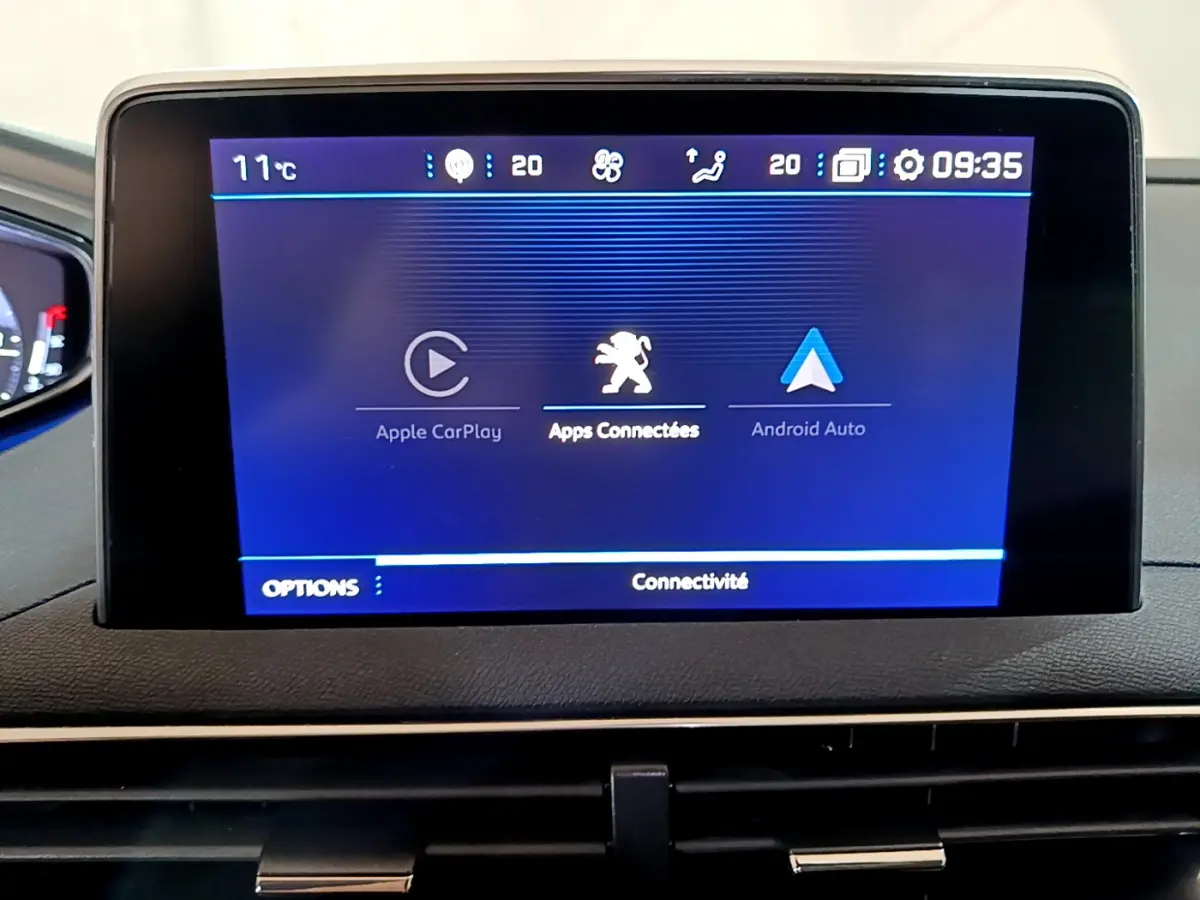 Écran tactile central affichant Apple CarPlay et Android Auto dans le tableau de bord du Peugeot 5008 gris clair.