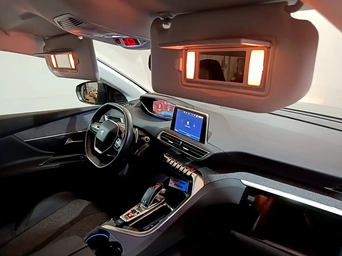 Intérieur du Peugeot 5008 2020 vu côté conducteur, tableau de bord avec écran tactile et miroirs de courtoisie éclairés.