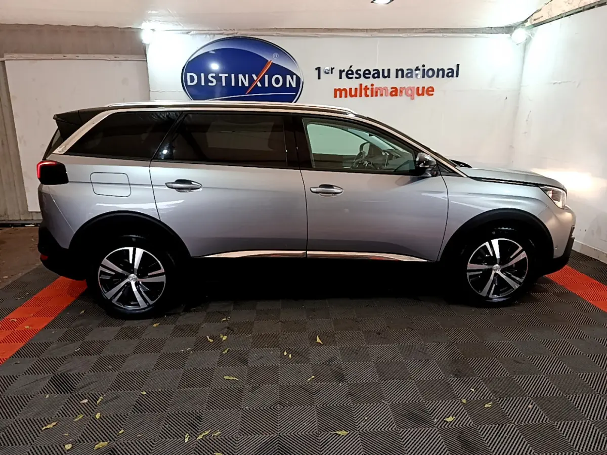 Profil côté gauche du Peugeot 5008 gris clair Puretech 130 Allure, avec vitres teintées et jantes alliage visibles.
