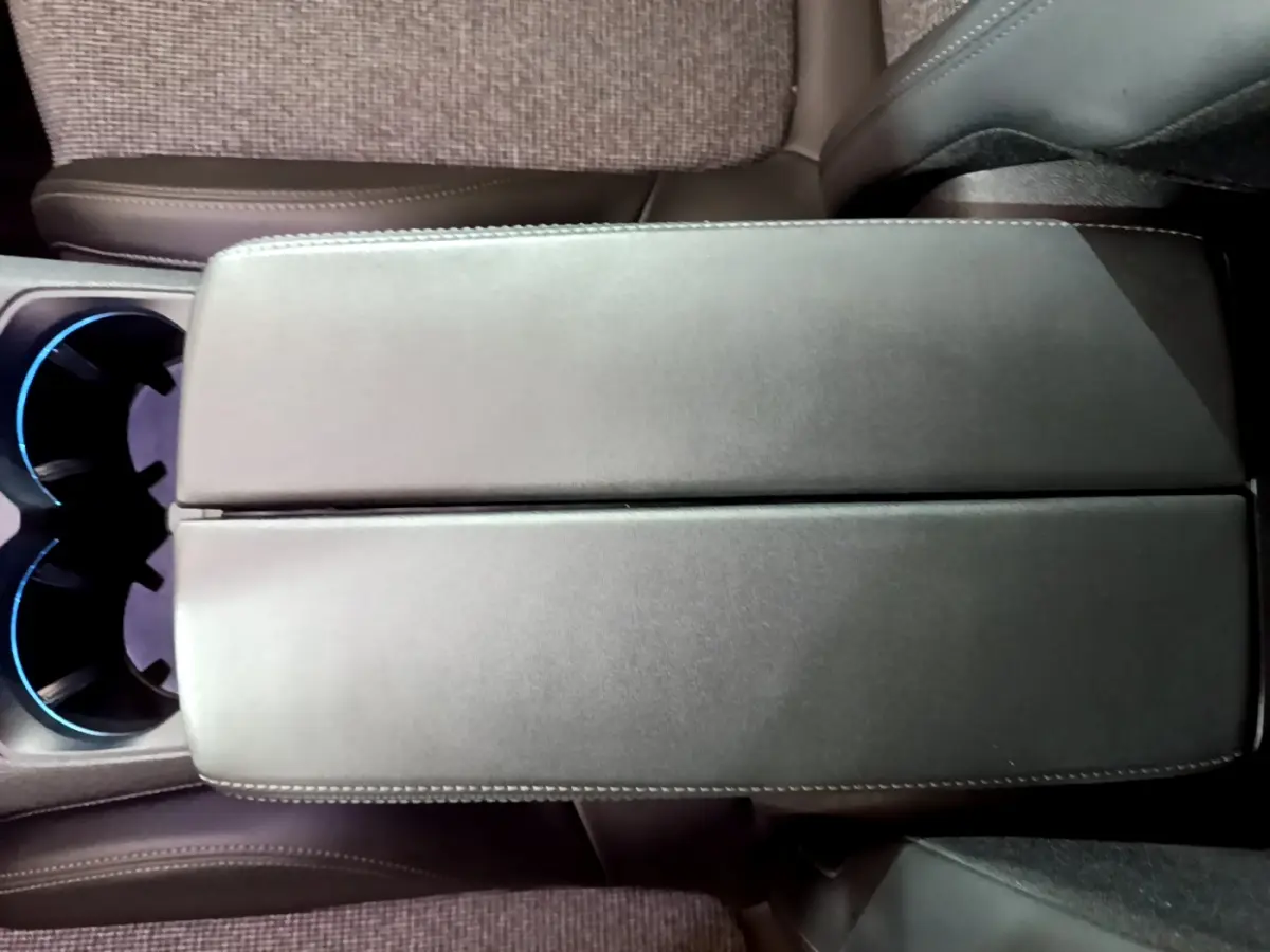 Vue plongeante sur l'accoudoir central en cuir noir et les porte-gobelets éclairés du Peugeot 5008 gris clair 2020.