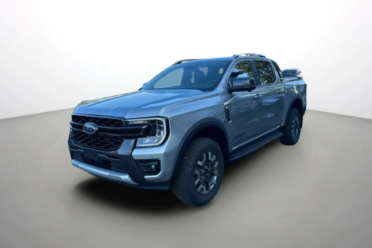 Ford Ranger PHEV gris iconic en 3/4 avant droit, double cabine avec barres de toit et jantes alu noires.