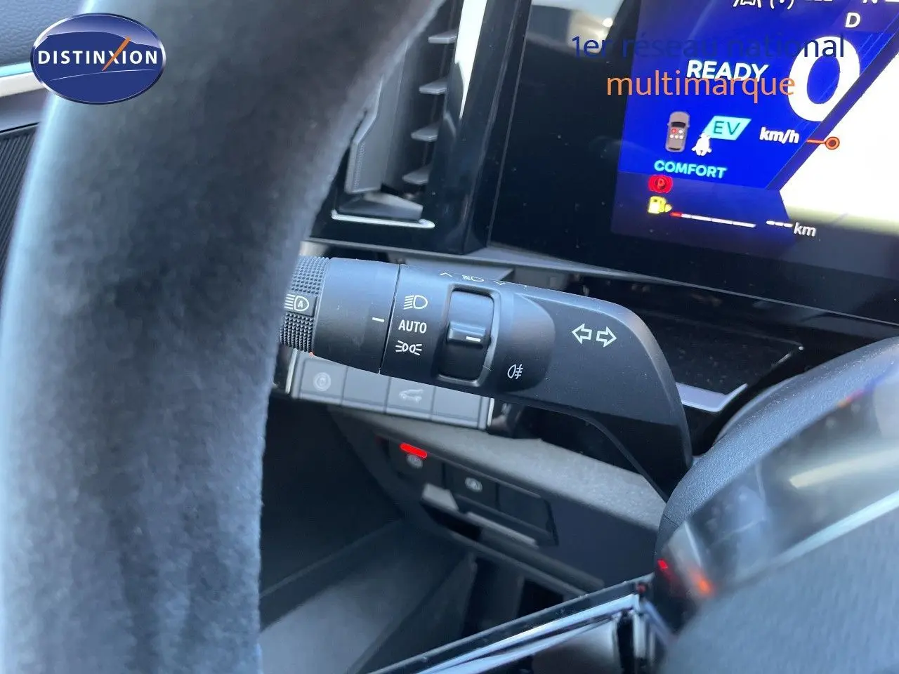 Gros plan sur la commande des phares et clignotants côté gauche du volant dans le tableau de bord noir du Renault Austral noir étoile métal.