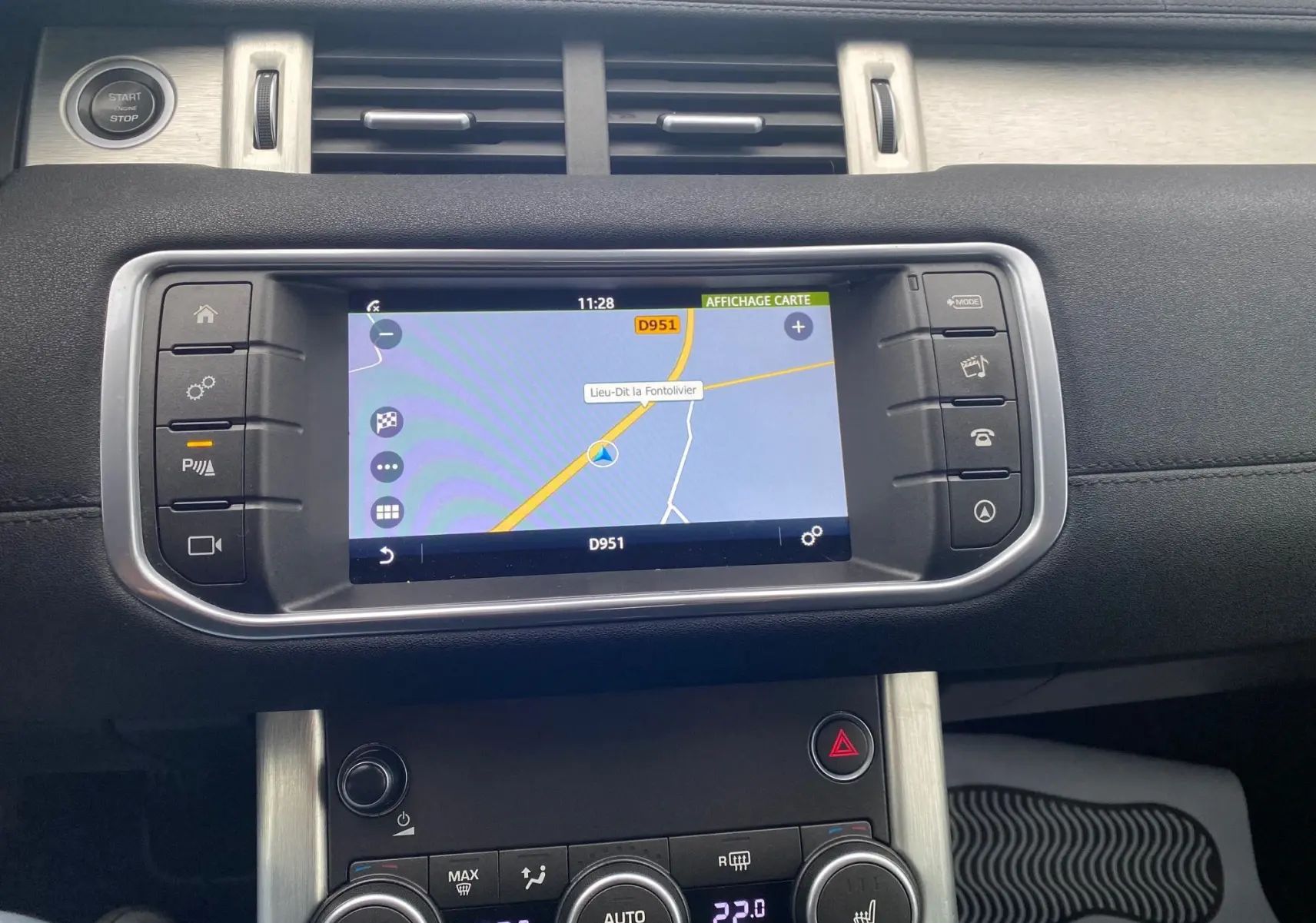 Tableau de bord noir du Range Rover Evoque 2016 avec écran GPS affichant une carte et commandes climatisation visibles