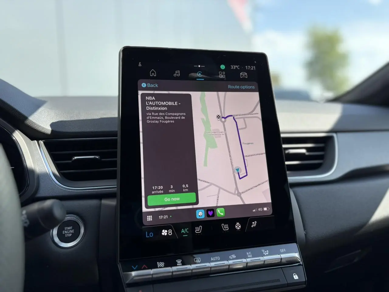 Écran tactile central du tableau de bord du Renault Captur 2025 affichant la navigation GPS et commandes climatisation.