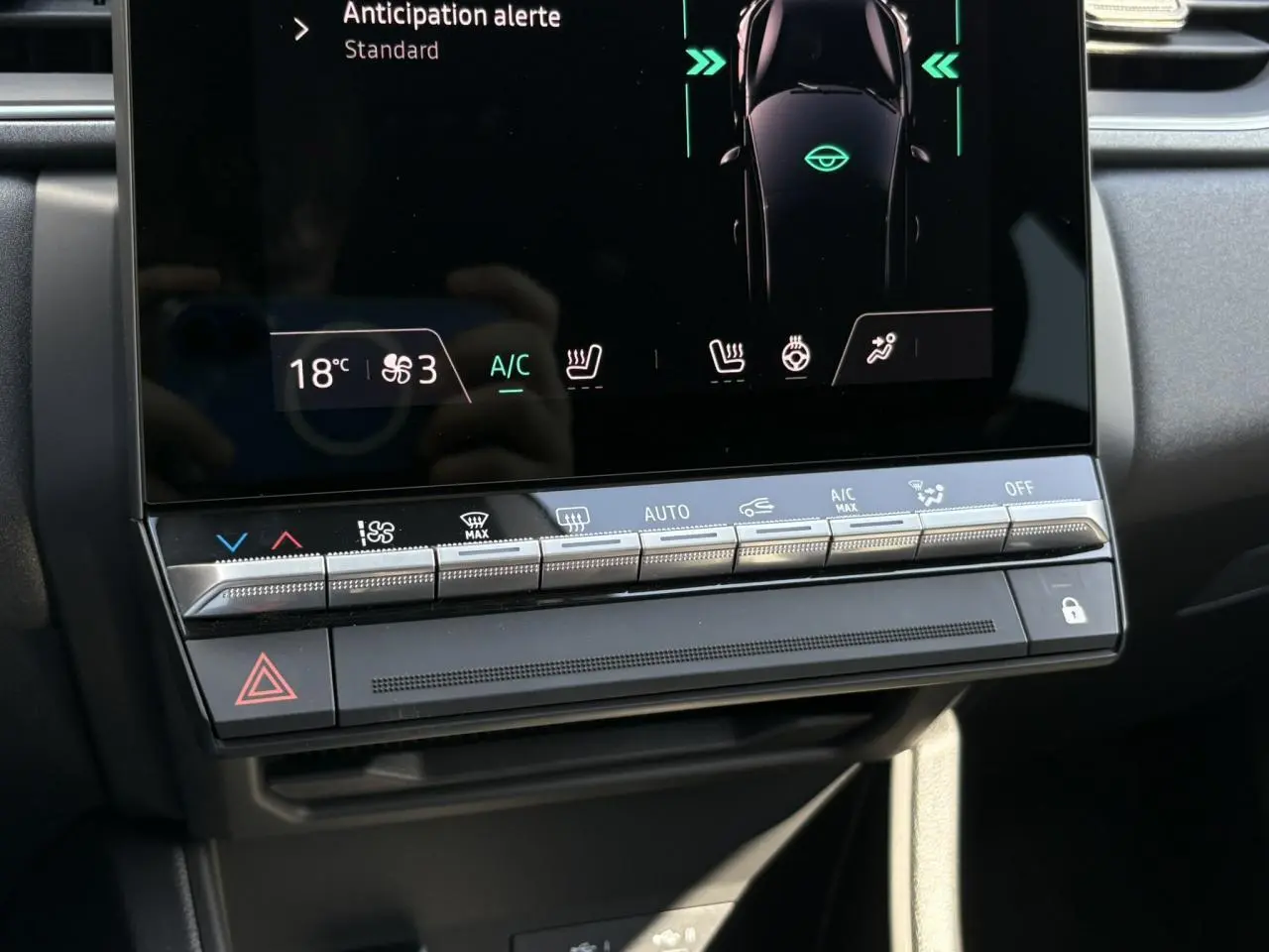 Détail du tableau de bord du Renault Captur 2025 avec commandes climatisation et écran tactile affichant l'alerte anticipation.