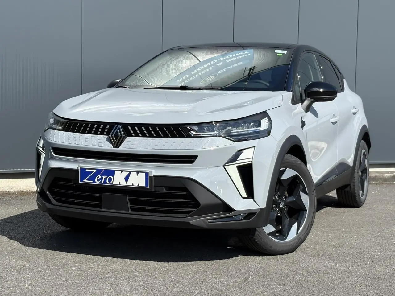 Vue 3/4 avant d'un Renault Captur gris rafale avec jantes noires et calandre moderne, sur fond neutre extérieur.