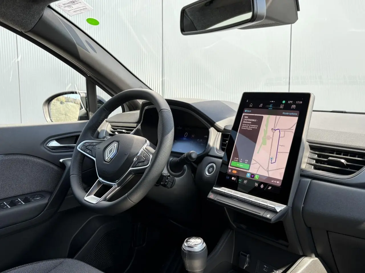 Intérieur du Renault Captur 2025 vu côté conducteur, volant multifonctions et écran tactile vertical avec navigation.