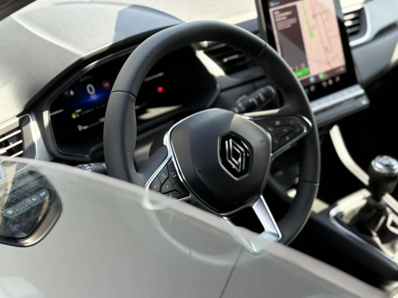 Vue rapprochée du volant multifonction noir et du tableau de bord numérique du Renault Captur 2025.