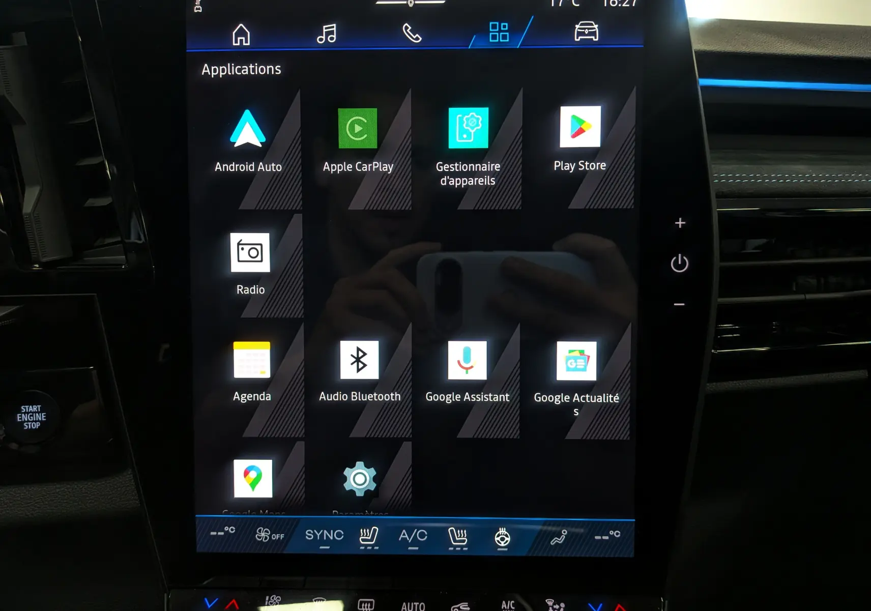 Écran tactile central du Renault Austral 2025 hybride, affichant les applications connectées dans l'habitacle noir.