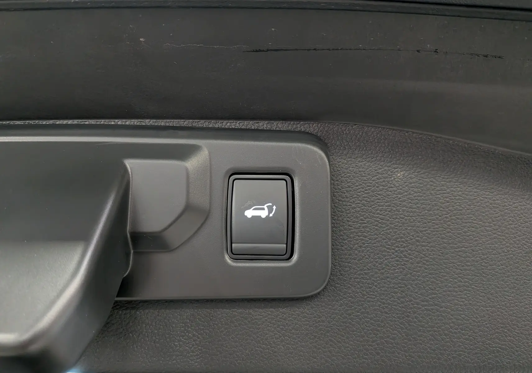 Bouton d'ouverture électrique du hayon sur le panneau intérieur d'un Renault Austral gris Schiste Satin 2025.