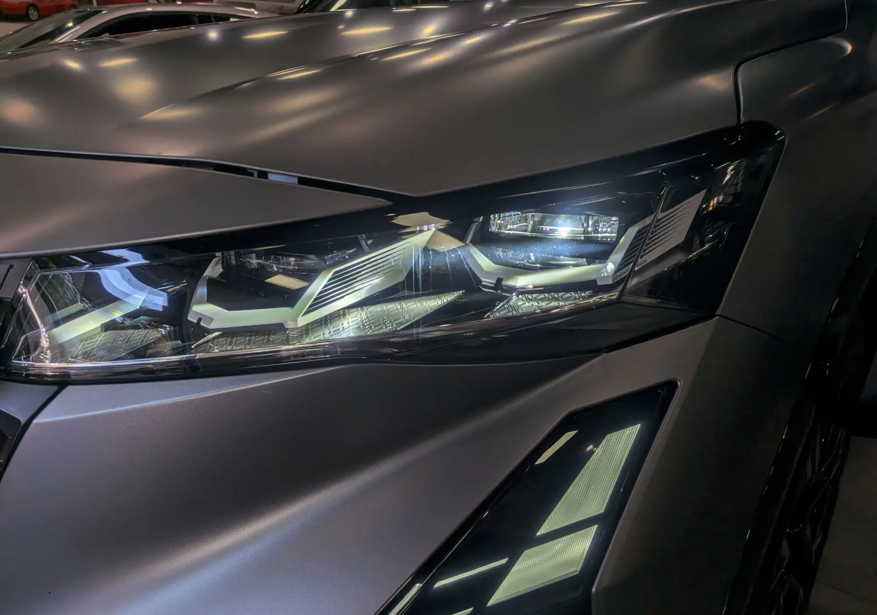 Gros plan sur le phare avant droit du Renault Austral gris Schiste Satin avec toit noir, éclairage LED distinctif.