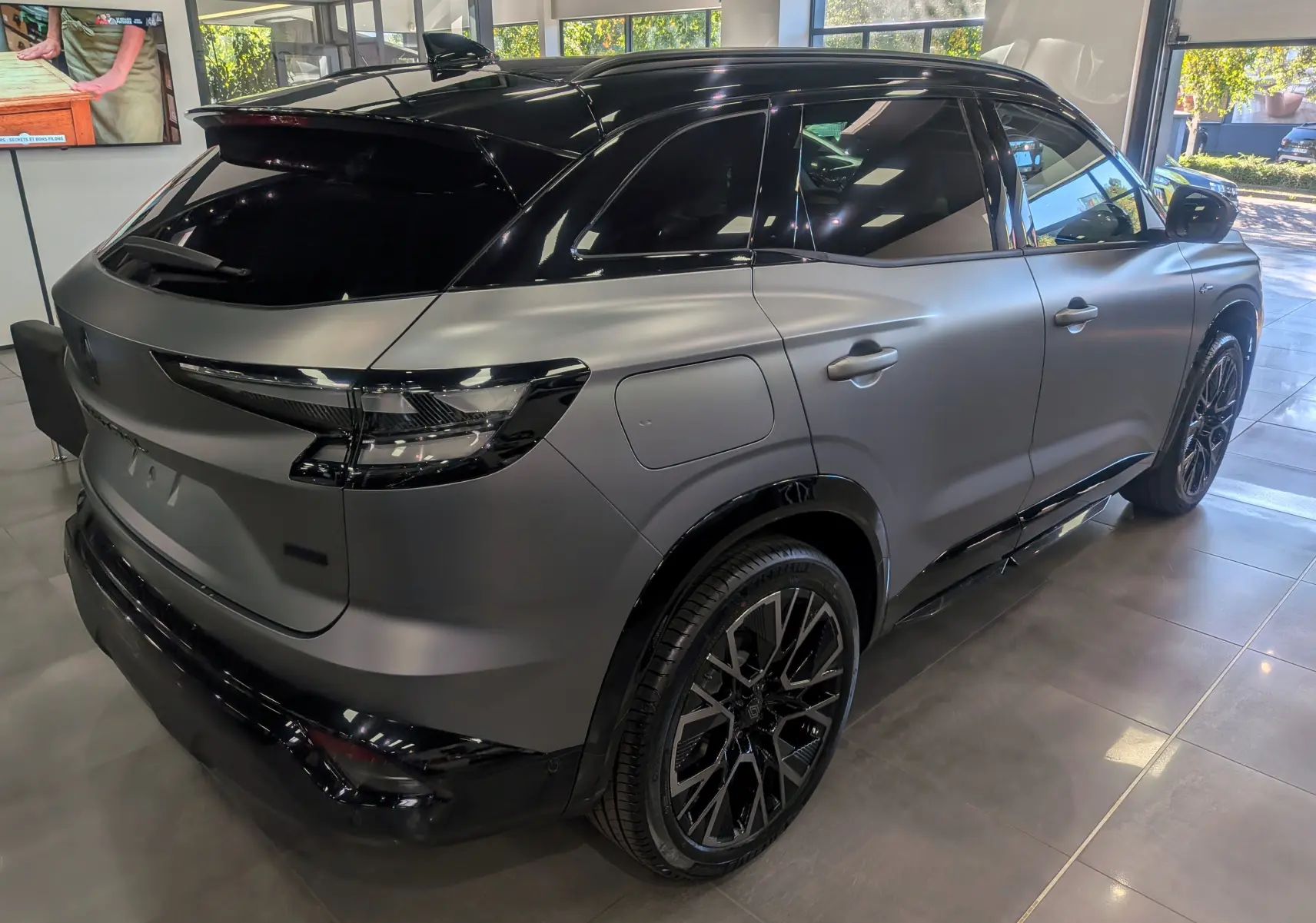 Vue 3/4 arrière droit du Renault Austral 2025 full hybride E-TECH gris schiste satin avec toit noir et jantes noires.