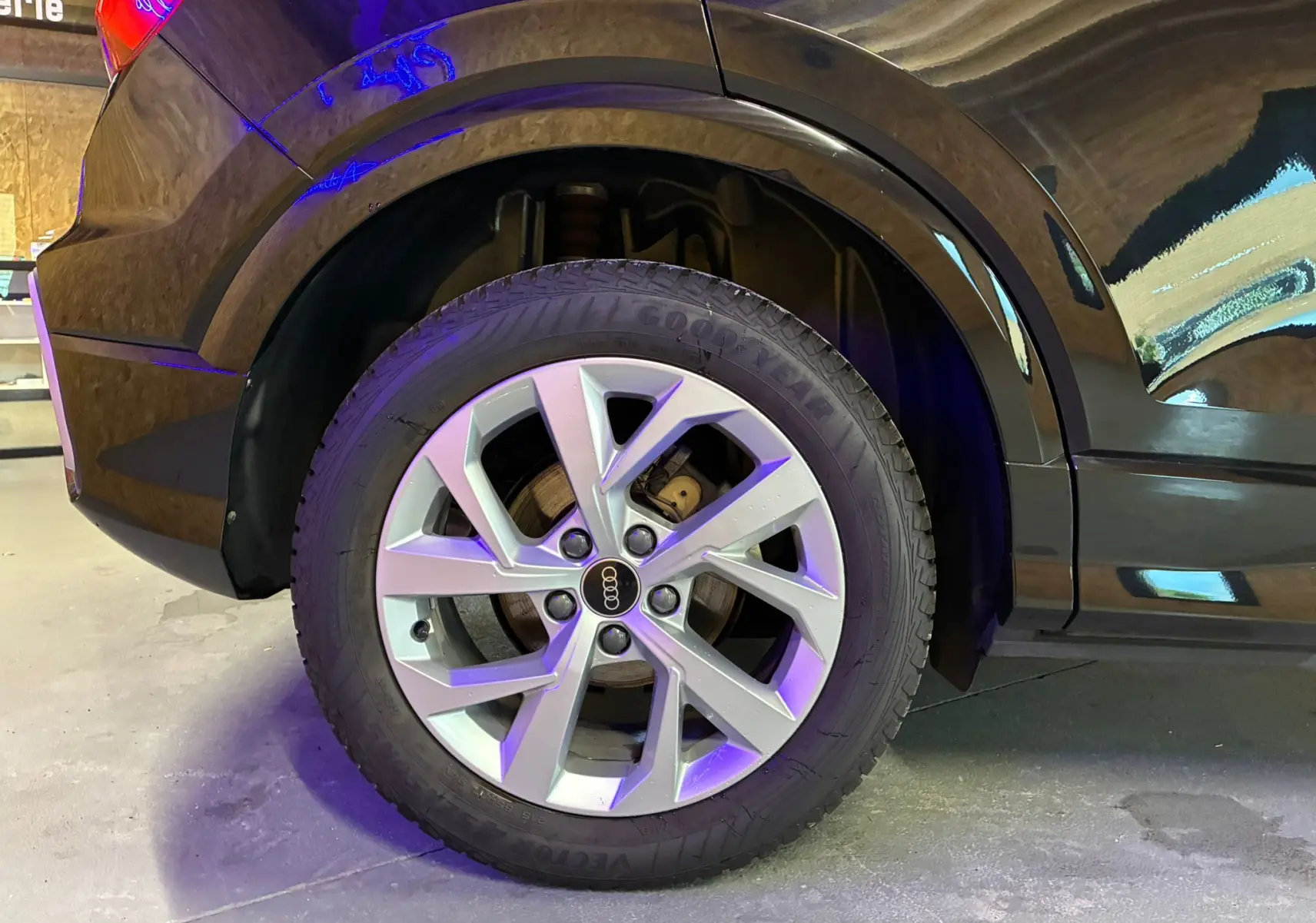 Gros plan sur la roue arrière droite d'un Audi Q2 noir 2023 avec jante alliage et pneu Goodyear.