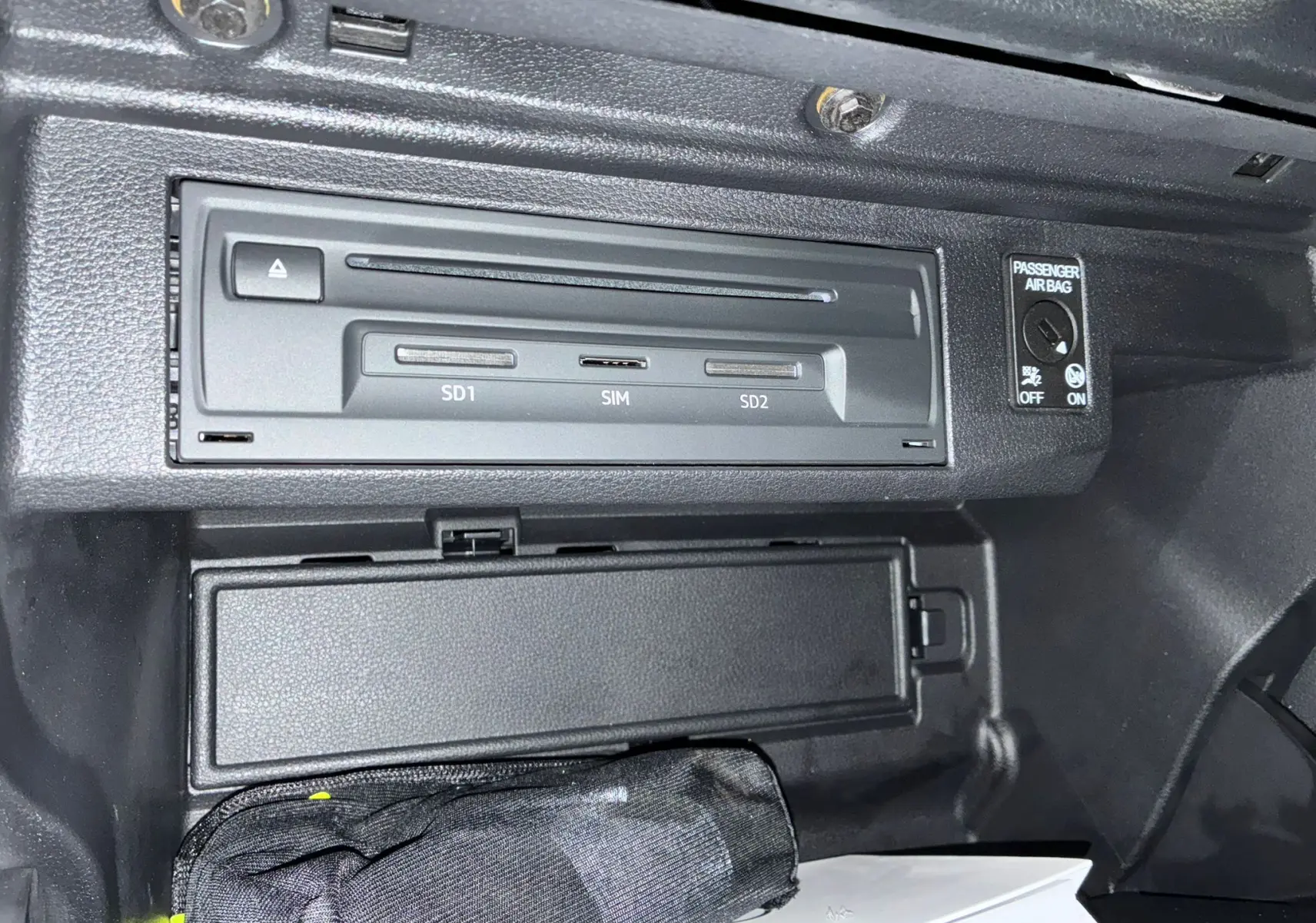 Gros plan sur le lecteur multimédia avec emplacements SD et SIM dans la boîte à gants d'un Audi Q2 noir 2023.