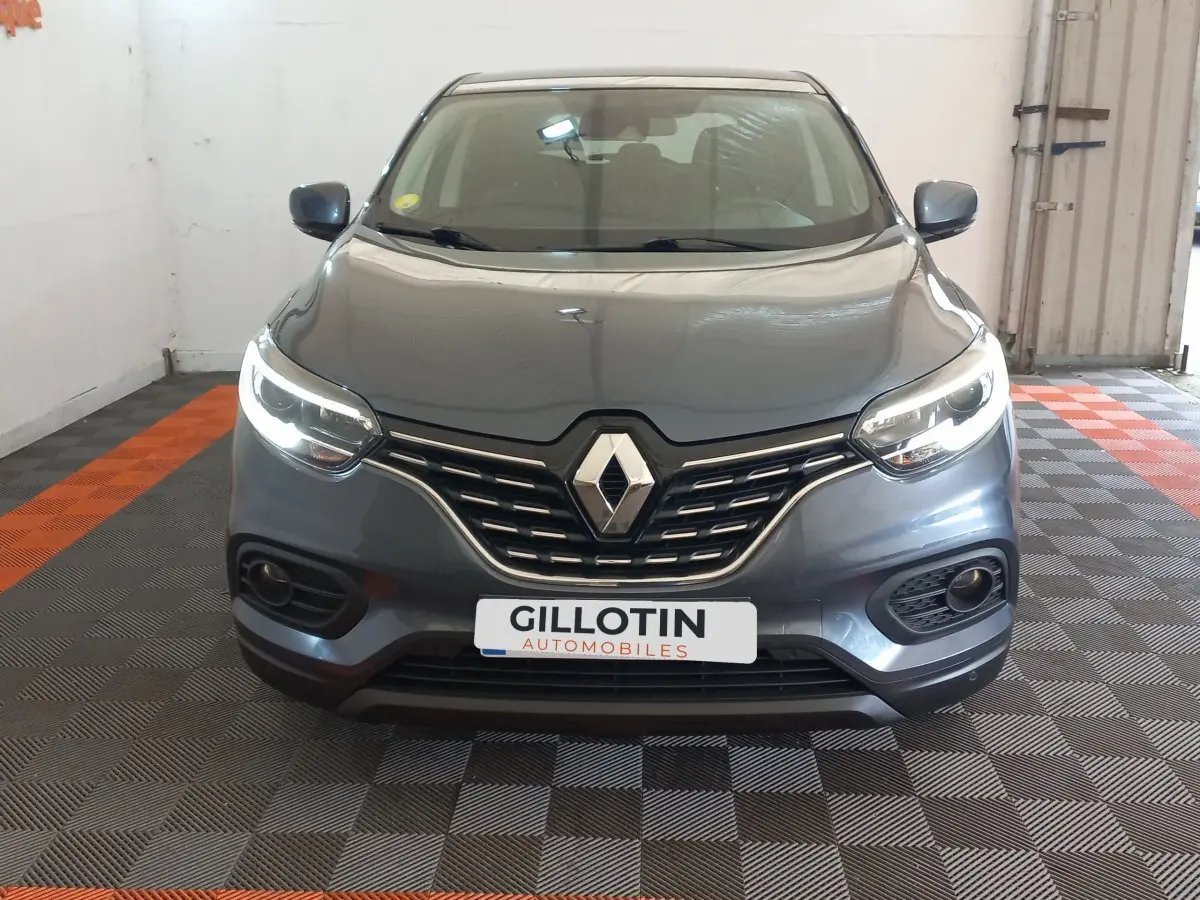 Vue frontale d’un Renault Kadjar Business gris foncé avec feux LED allumés dans un garage.