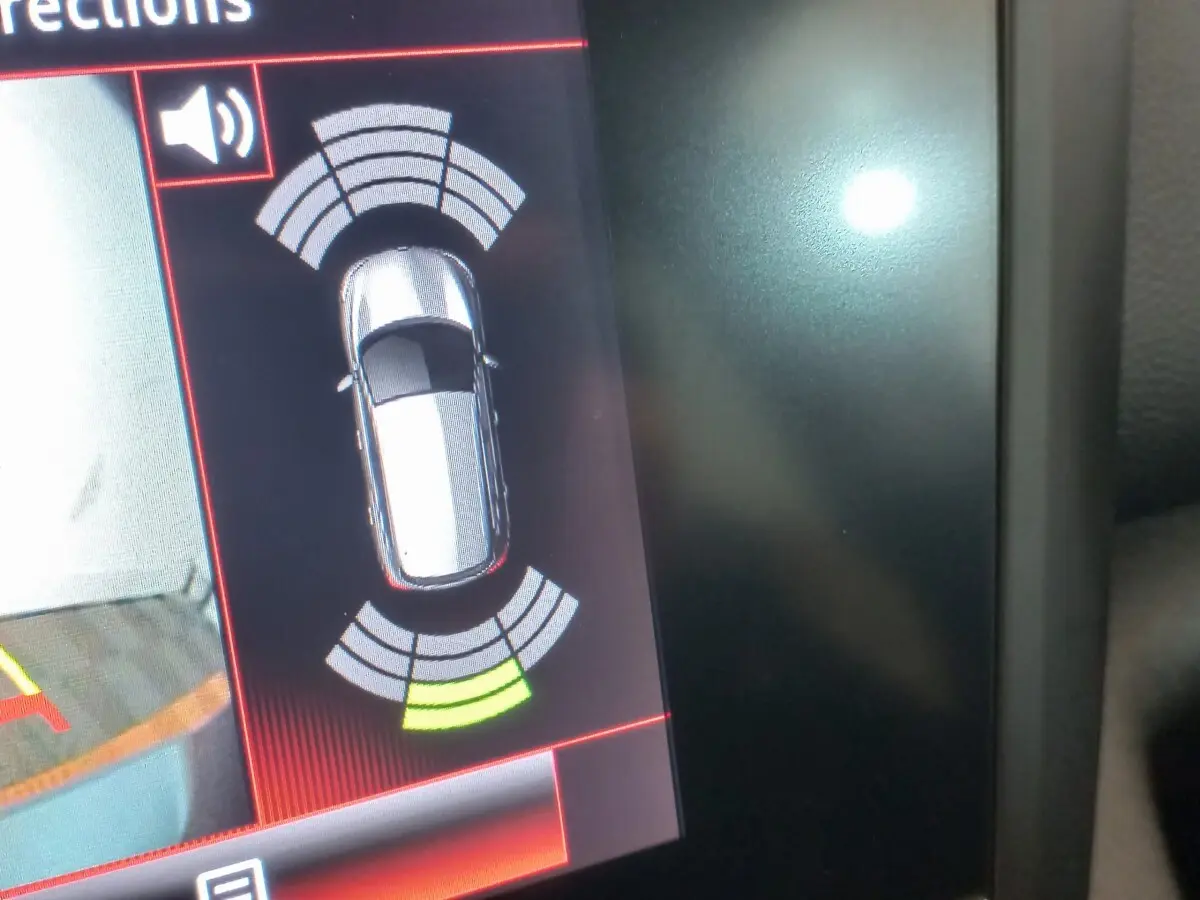 Affichage du système d'aide au stationnement montrant une Renault Kadjar gris foncé vue de dessus sur l'écran tactile.