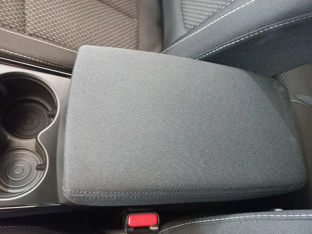 Gros plan sur l'accoudoir central en tissu gris foncé et porte-gobelets du Renault Kadjar Business 2022.