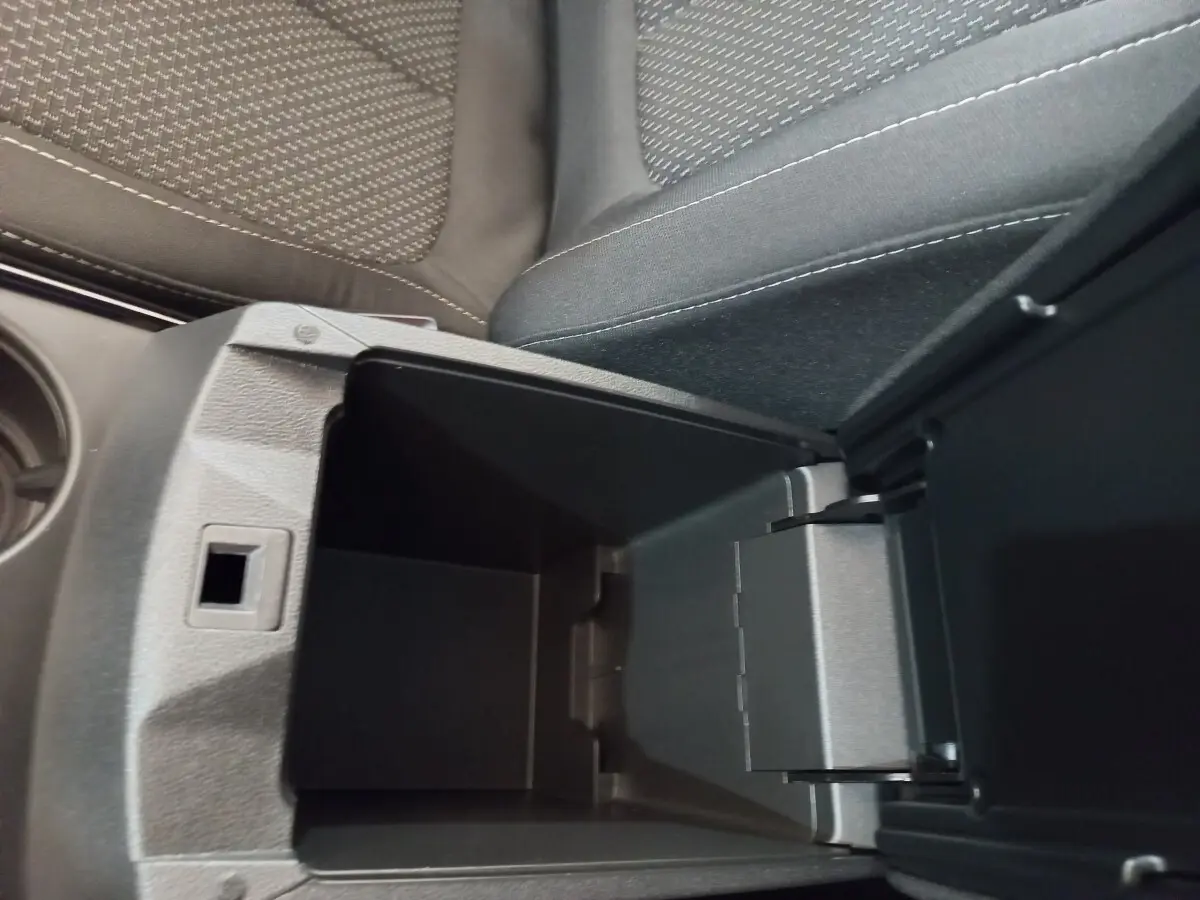 Vue intérieure en gros plan du rangement central ouvert entre les sièges tissu gris du Renault Kadjar Business 2022.