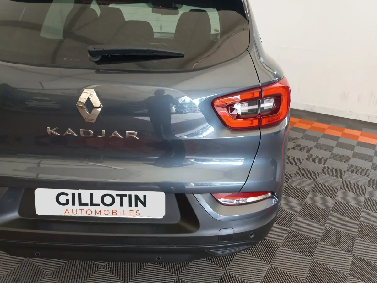 Vue arrière côté droit du Renault Kadjar gris foncé avec feux arrière LED et logo visible sur un sol à damiers.