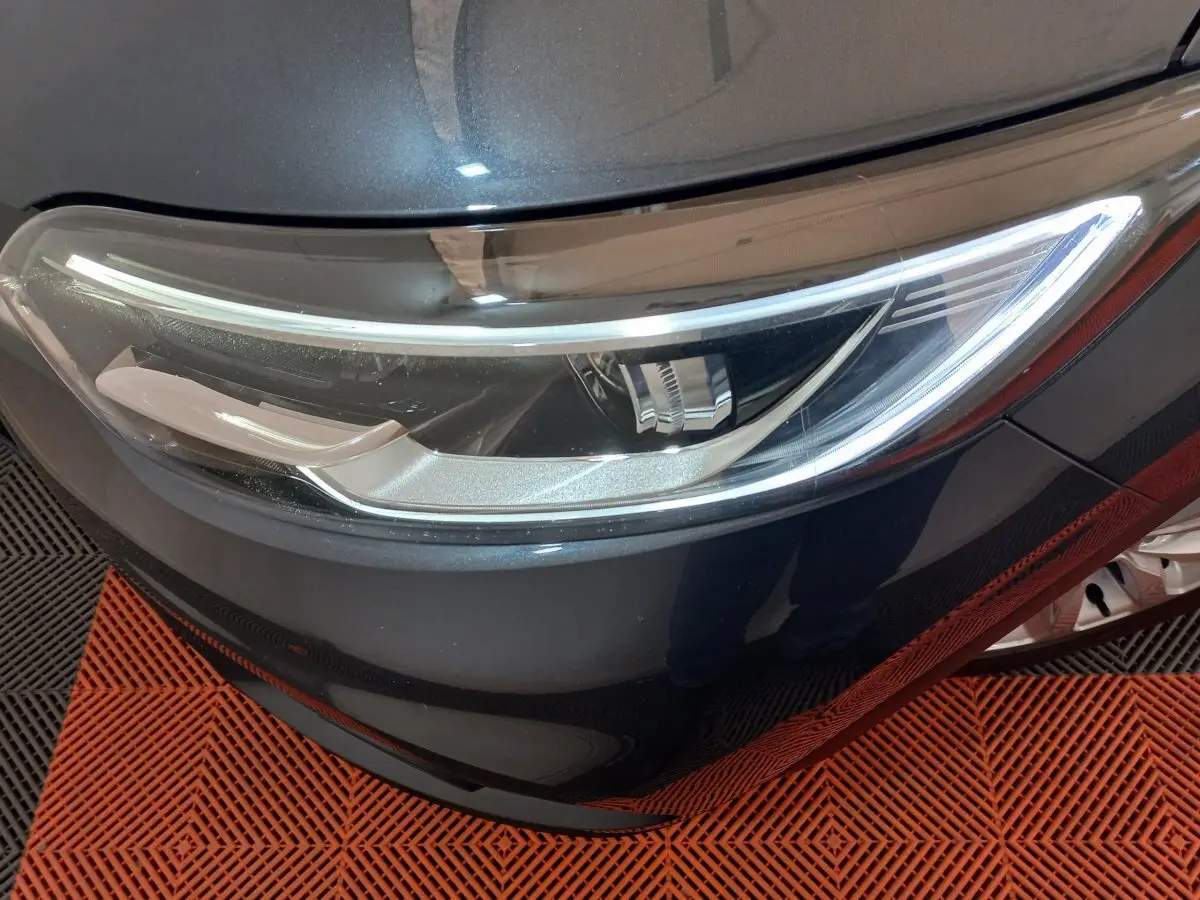 Gros plan sur le phare avant droit du Renault Kadjar gris foncé, mettant en valeur son design moderne et épuré.