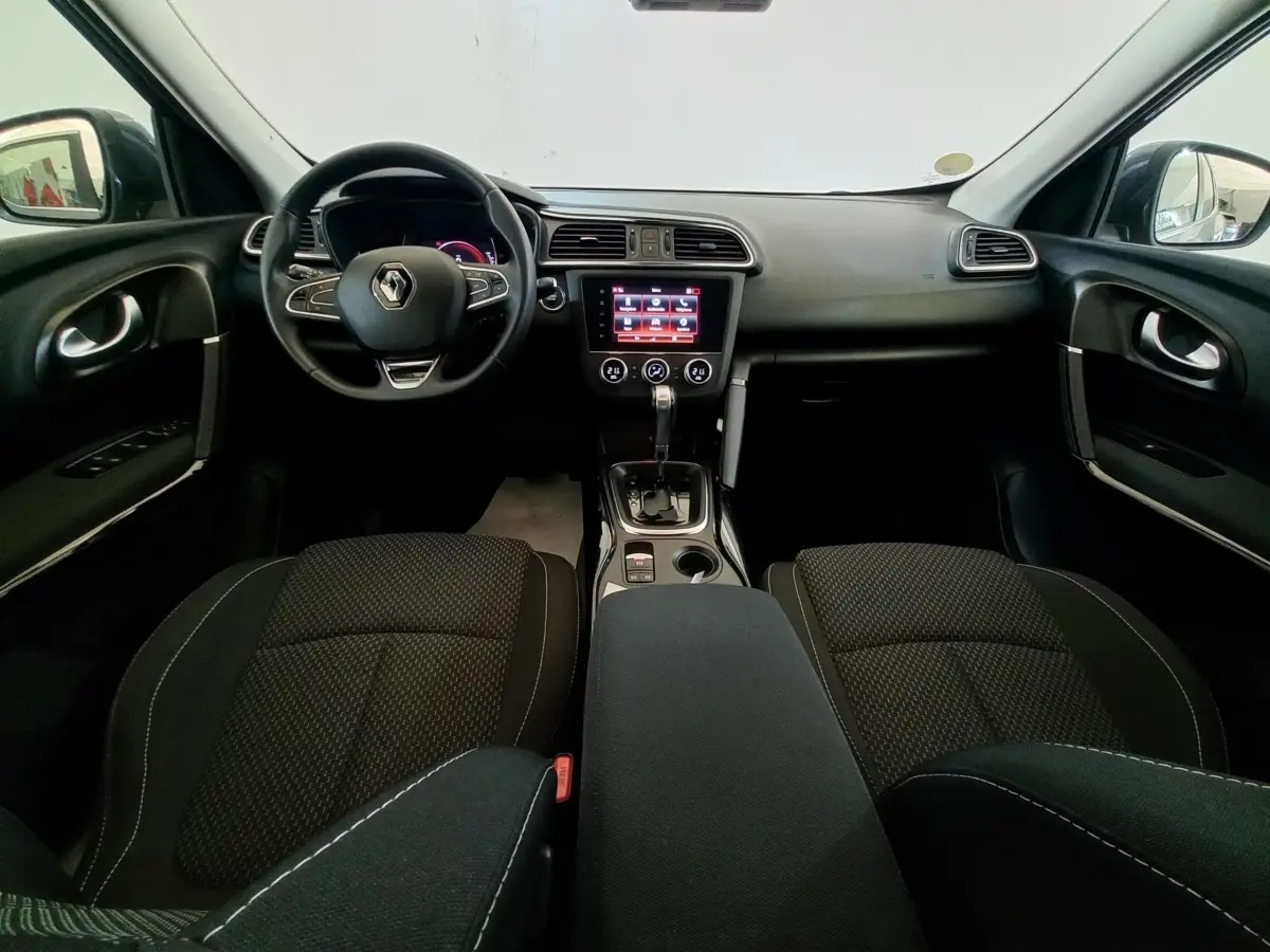 Vue intérieure avant du Renault Kadjar 2022 Business Blue dCi, montrant le tableau de bord noir et l'écran tactile central.