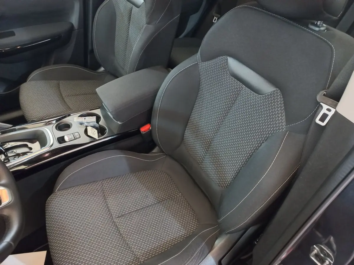 Vue intérieure rapprochée des sièges avant gris foncé avec console centrale brillante du Renault Kadjar Business 2022.