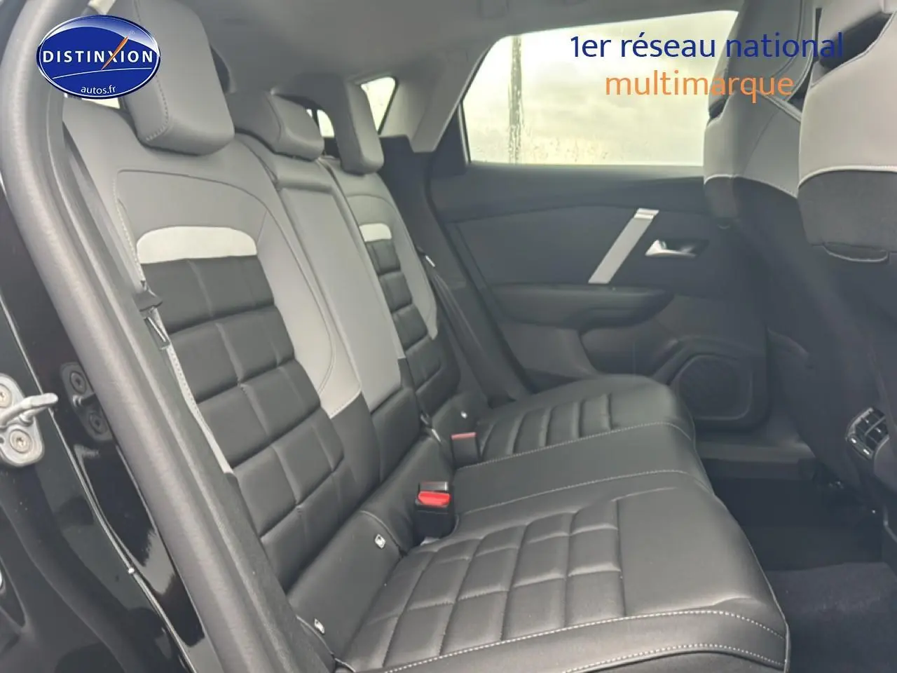 Vue intérieure côté gauche sur la banquette arrière noire et grise d'une Citroën C4 2025 hybride automatique.