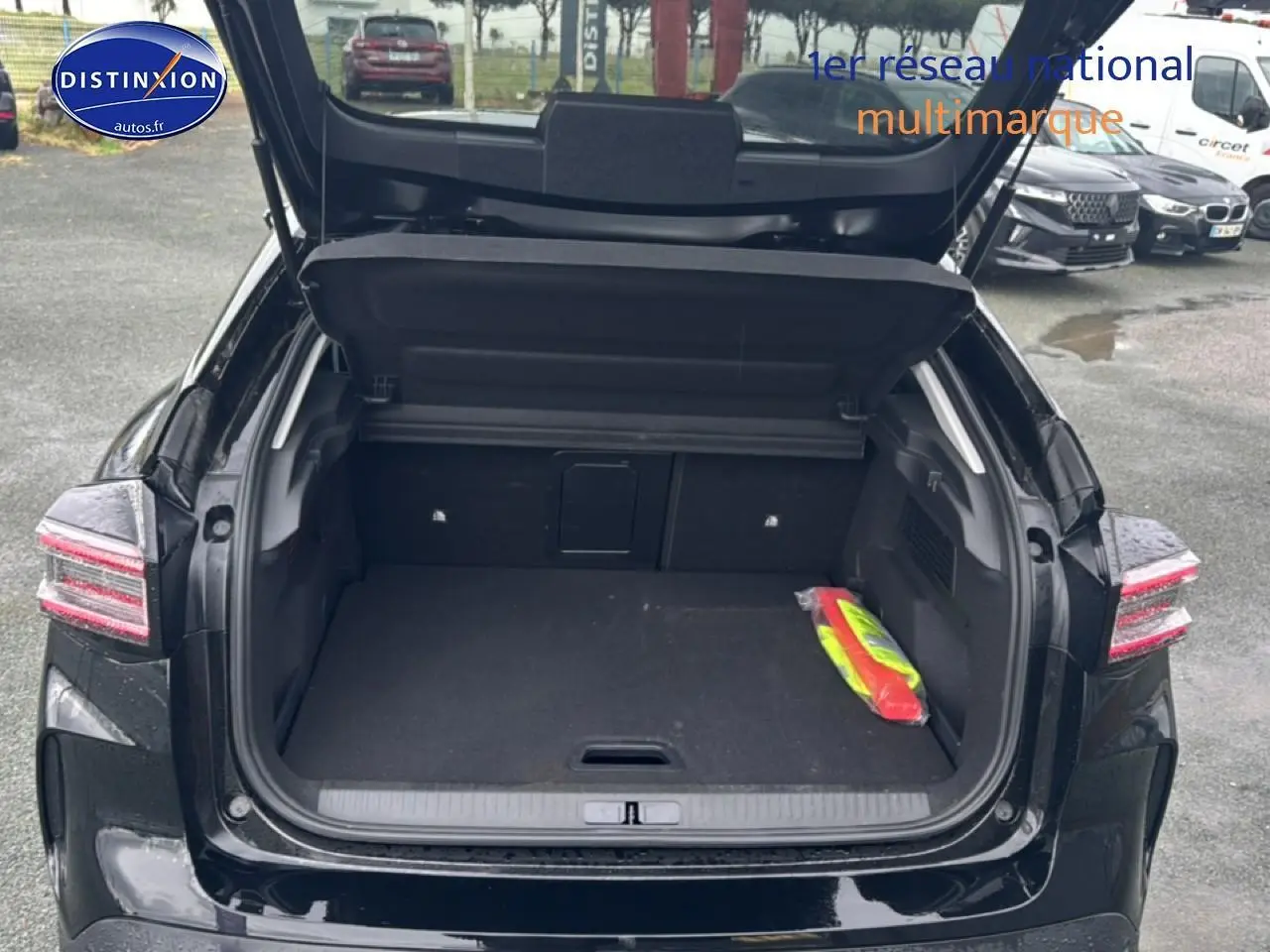 Vue arrière ouverte sur le coffre spacieux d'une Citroën C4 noire 2025, avec trappe à skis visible à l'intérieur.