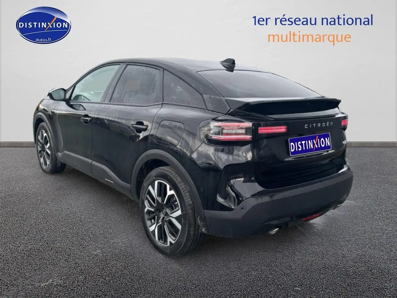Vue 3/4 arrière droite d'une Citroën C4 noire 2025 avec jantes alu et feux arrière LED distinctifs.