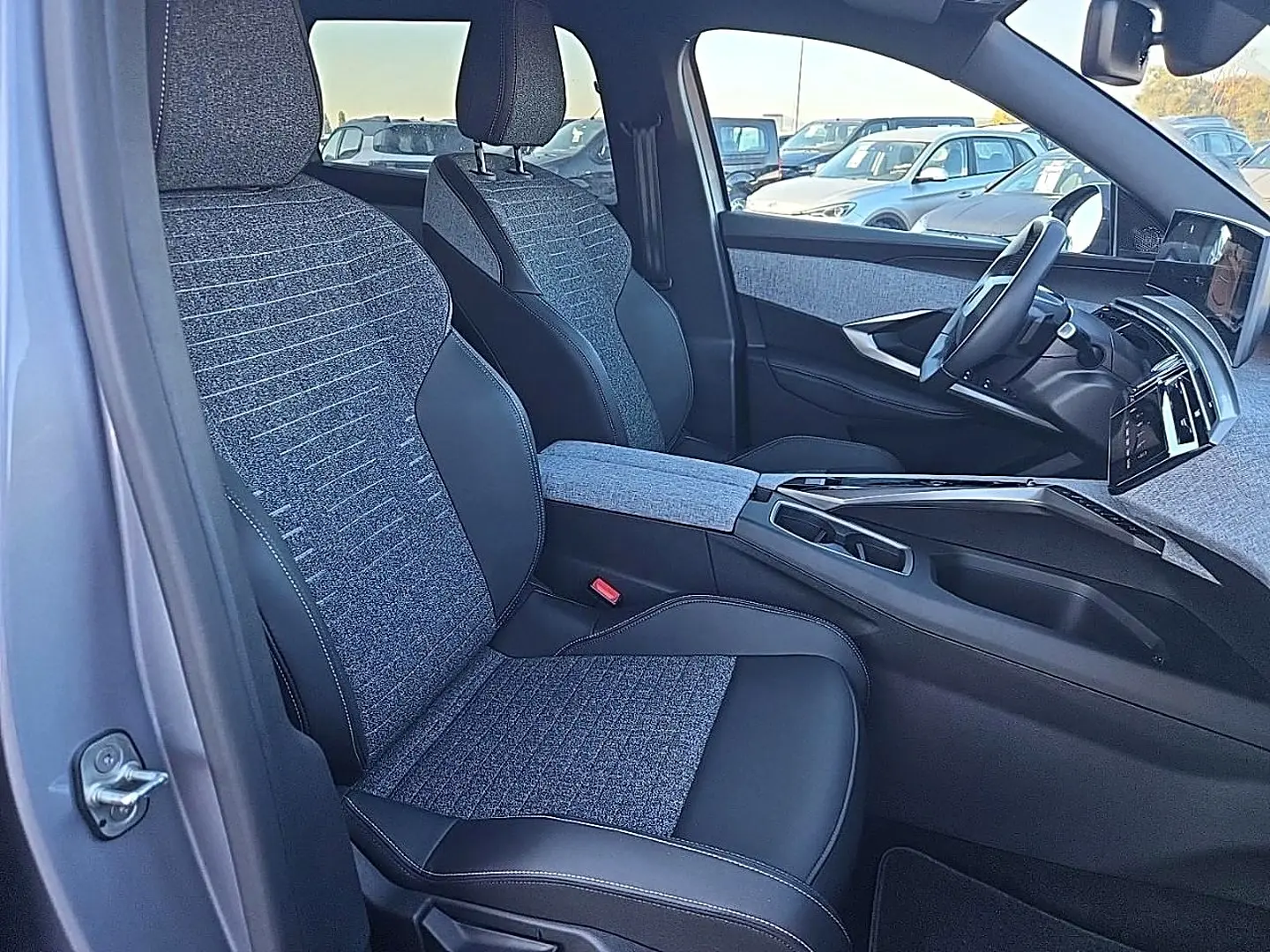 Vue intérieure côté gauche des sièges avant gris tissu et cuir du Peugeot 5008 Hybrid 145 allure e-dcs6 2025.