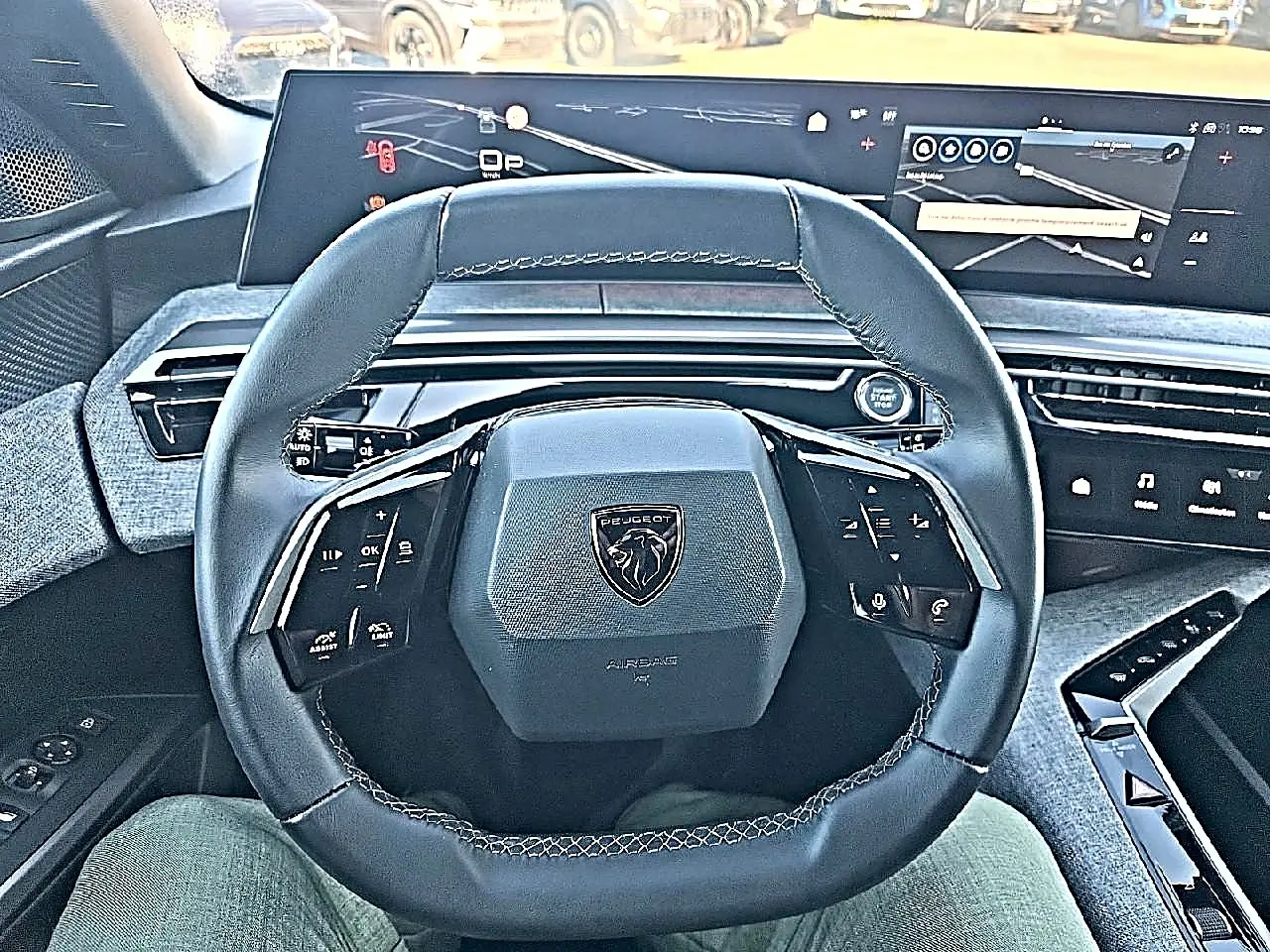 Vue intérieure centrée sur le volant cuir multifonction noir du Peugeot 5008 2025 avec tableau de bord numérique.