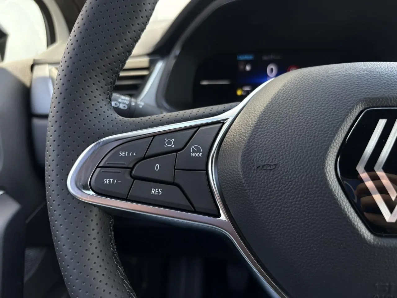 Gros plan sur le volant perforé à commandes intégrées du Renault Captur blanc nacré 2025, version ECO-G 100 Techno.