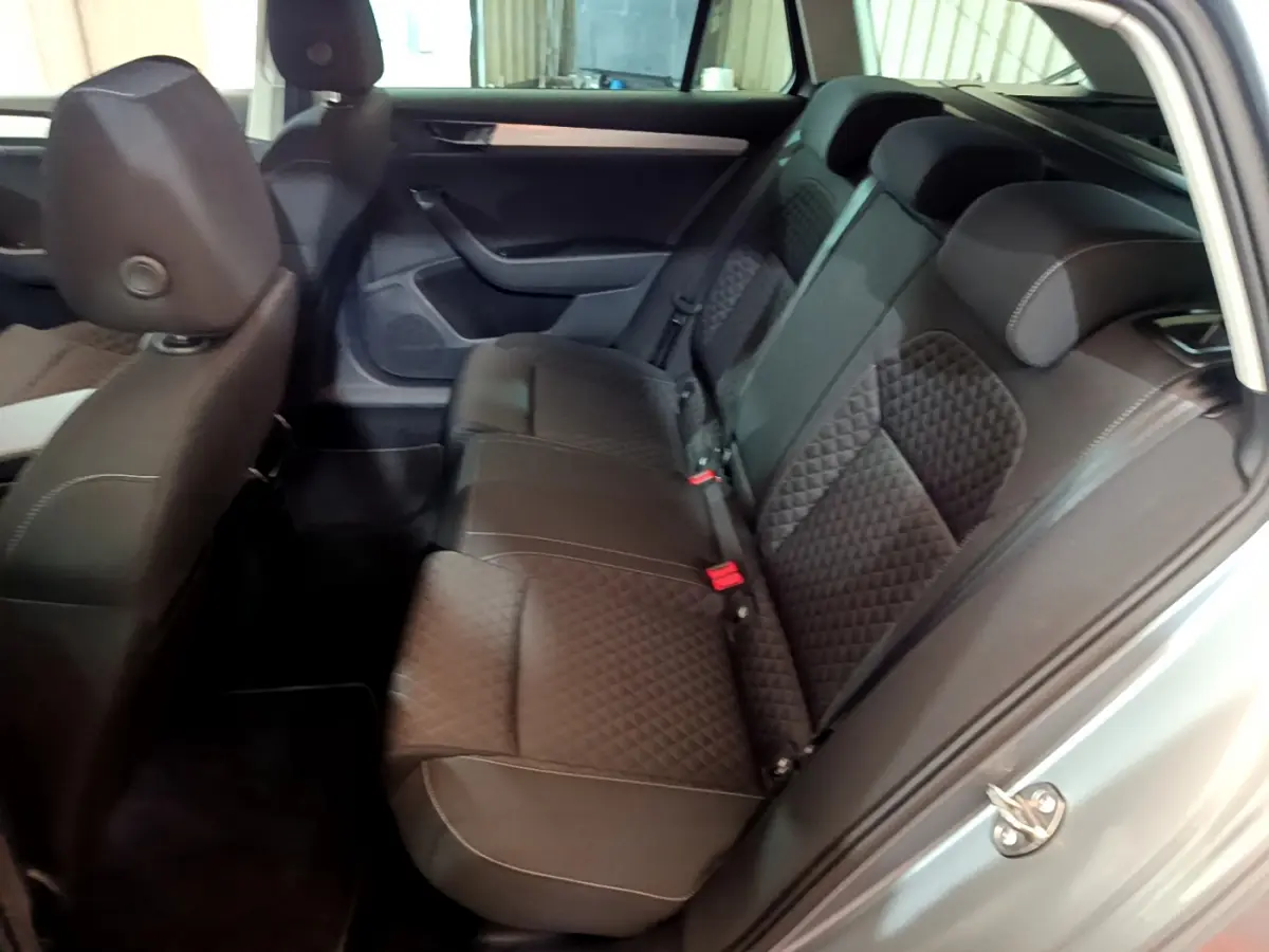 Vue intérieure côté droit sur la banquette arrière en tissu noir matelassé d'une Skoda Superb gris clair 2020.