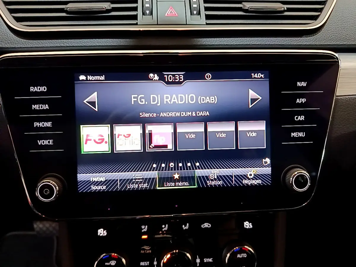 Écran tactile central de la Skoda Superb 2020 affichant la radio DAB, entouré de commandes noires et bois clair.