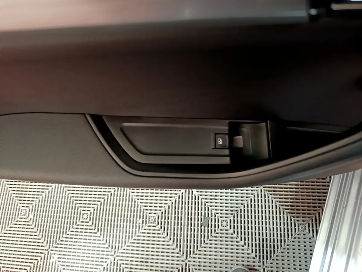 Détail de la poignée intérieure de porte côté droit d'une Skoda Superb gris clair, avec bouton de verrouillage.