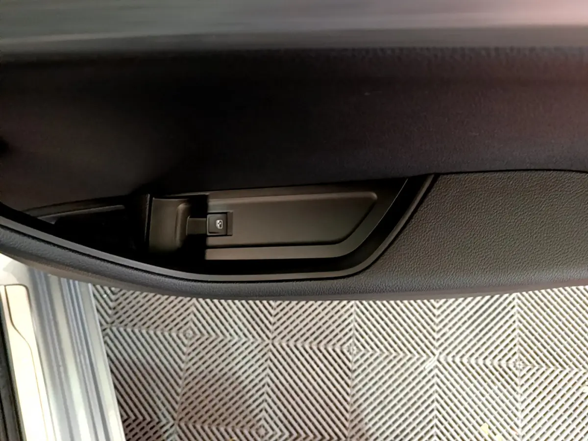 Détail de la poignée intérieure de porte côté conducteur d'une Skoda Superb gris clair 2020.